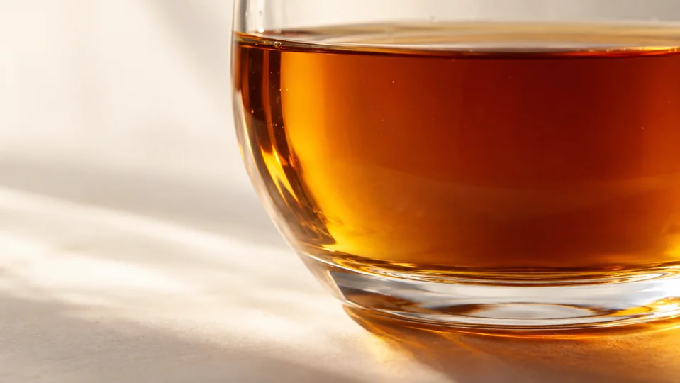 Nahaufnahme von bernsteinfarbenem Sirup in einem Glas